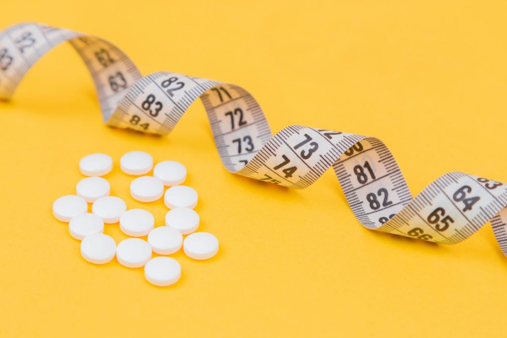 white round medication pill on yellow surface Alpilean