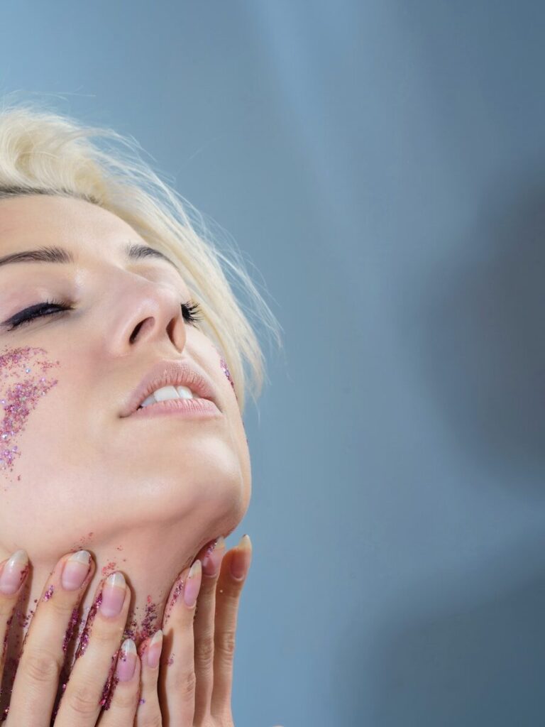 woman using at-home skin tightening device on face for jawline definition